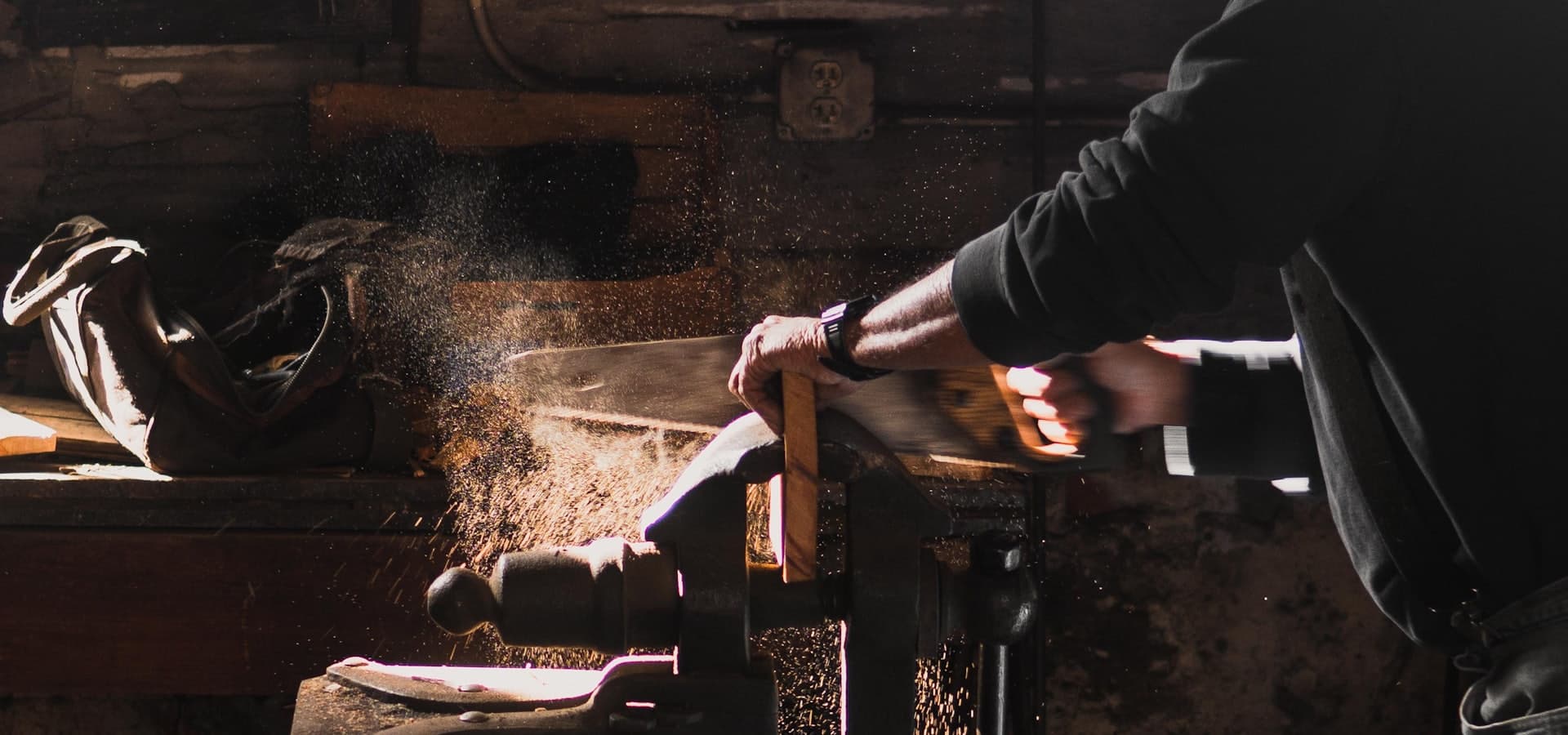A tradesperson cutting timber in a workshop
