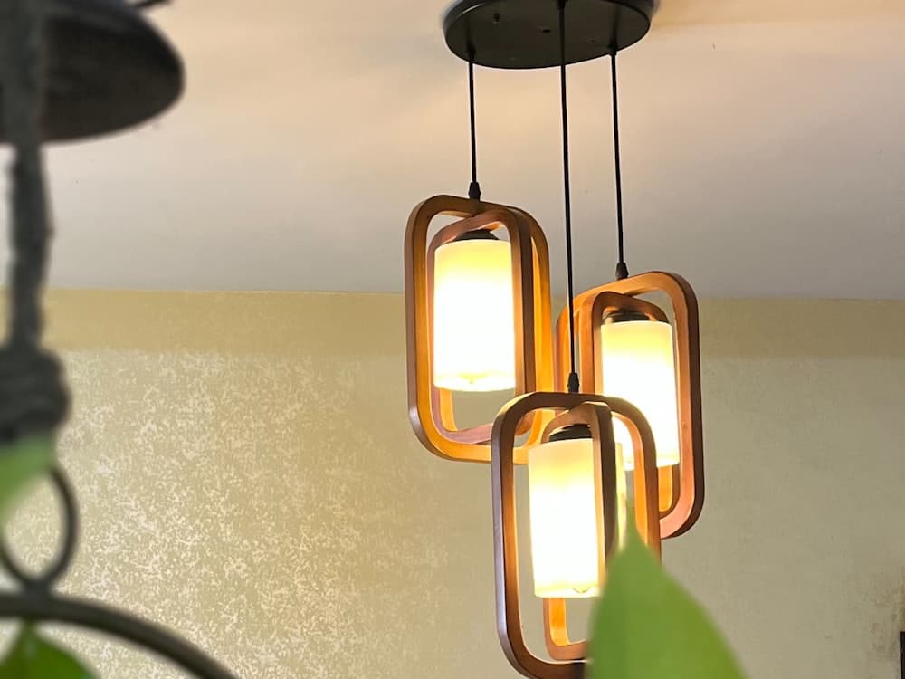Warm timber-framed pendant lights hanging above a counter