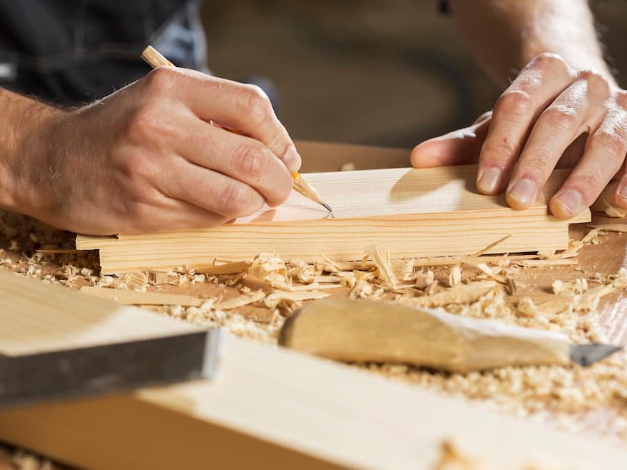 Hands marking a cut line on a length of timber with a pencil