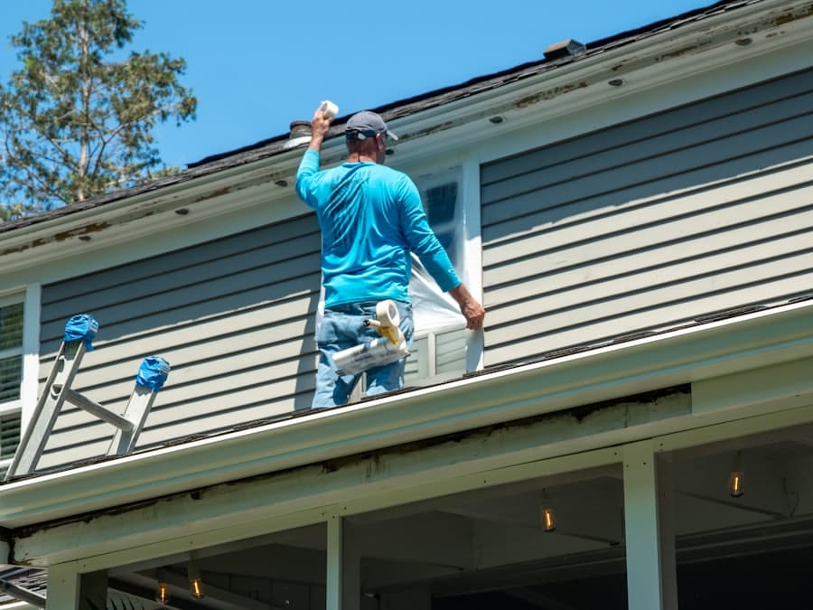 A tradesperson working along a soffit from a ladder